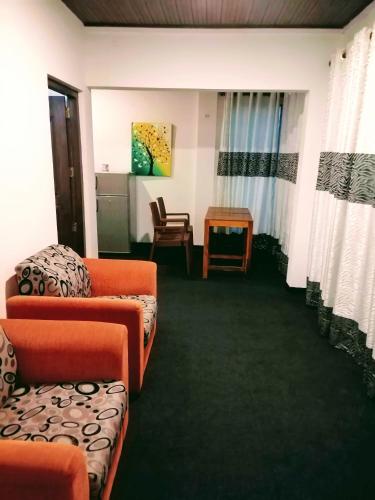 a room with two couches and a table and a chair at Villa Yuvin in Matara