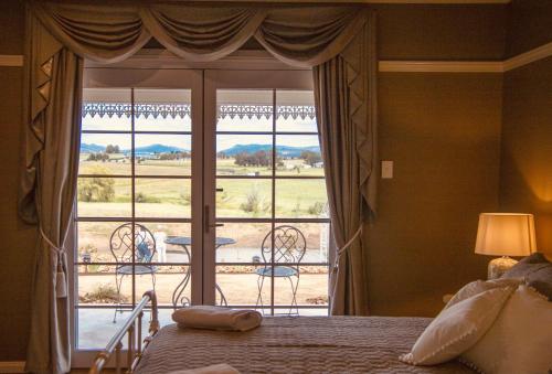 a bedroom with a bed and a large window at Carpe Diem Guesthouse in Tenterfield