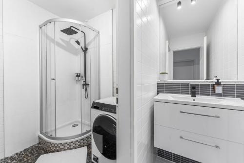 y baño con ducha y lavadora. en 100sqm Luxury Apt in Prime Location near Ku'Damm en Berlín