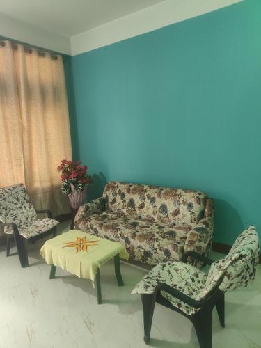 sala de estar con sofá, mesa y sillas en S house, en Guwahati