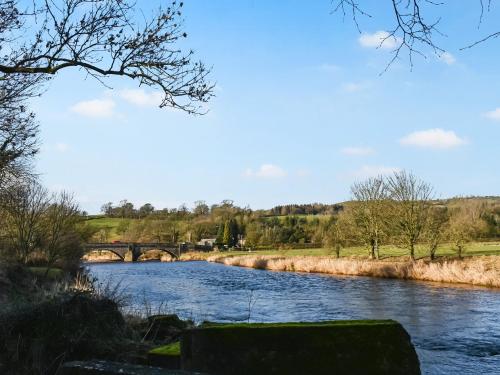 a river with a bridge in the background at Rose Cottage in Foulridge