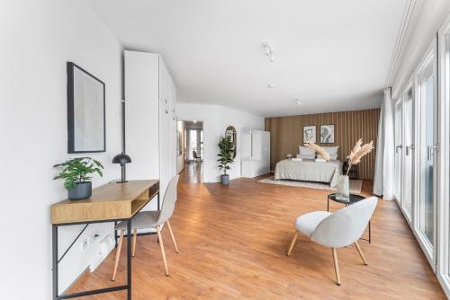 ein Wohnzimmer mit einem Schreibtisch, Stühlen und einem Bett in der Unterkunft 100sqm Luxury Apt in Prime Location near Ku'Damm in Berlin