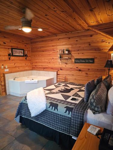 a bedroom with a bed and a tub in a log cabin at 5 Min To Beaver Lake, King Bed, Fire Pit, Jetted Tub #2 in Eureka Springs