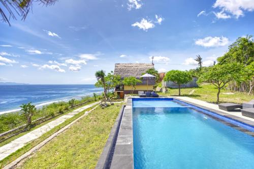 an infinity pool with the ocean in the background at Song Cang Bungalow in Nusa Penida