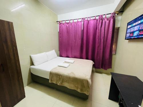 a small room with a purple window and a bed at Hotel City Bukit Bintang in Kuala Lumpur
