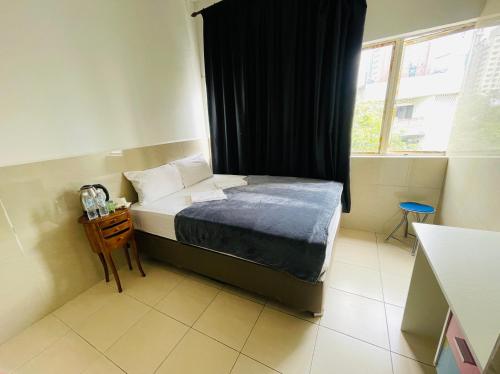 a small bedroom with a bed and a window at Hotel City Bukit Bintang in Kuala Lumpur