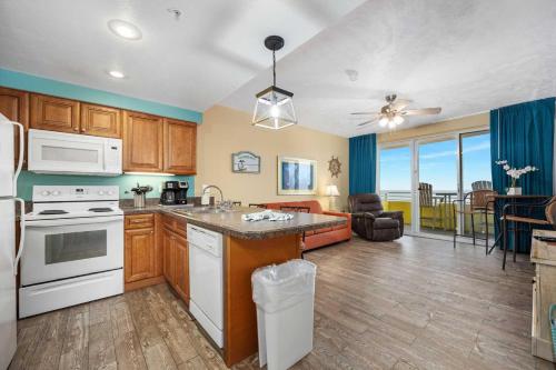a kitchen with white appliances and a living room at Luxury 16th Floor 1 BR Condo Direct Oceanfront Wyndham Ocean Walk Resort Daytona Beach | 1610 in Daytona Beach