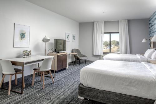 サバンナにあるTownePlace Suites by Marriott Savannah Airportのベッド2台とデスクが備わるホテルルームです。