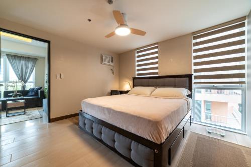 a bedroom with a bed and a large window at Luxury Condo at Venice Mall near Airport, BGC & Makati in Manila
