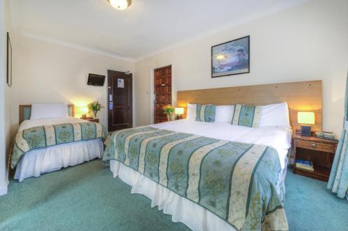 a hotel room with two beds and a television at The Dolphin Hotel in Great Yarmouth