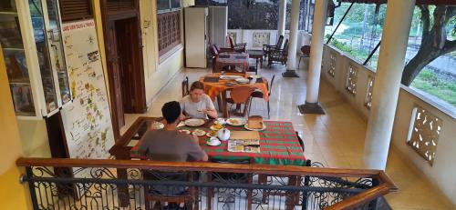 two people sitting at a table in a restaurant at Henderson Airport Residence in Negombo