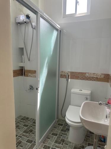 La salle de bains est pourvue d'une douche, de toilettes et d'un lavabo. dans l'établissement Clubmiller Guesthouse, à Puerto Princesa