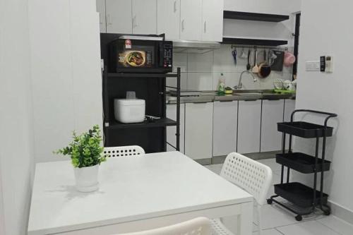 a kitchen with a white table and a microwave at 3 Bedrooms -Astetica-The Mines in Seri Kembangan