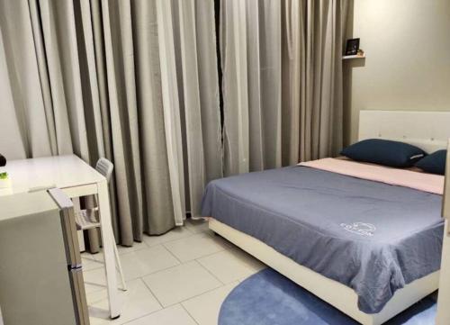 a bedroom with a bed and a table and curtains at 3 Bedrooms -Astetica-The Mines in Seri Kembangan