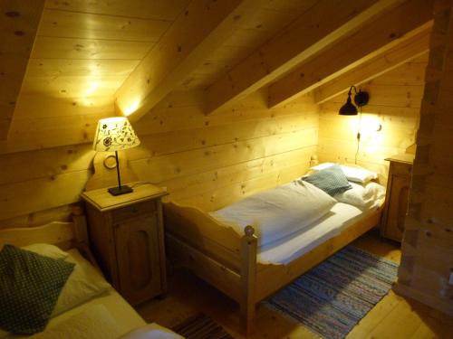 a bedroom with a bed in a wooden room at Knusperhäusl in Uttendorf