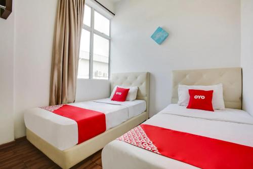 two beds with red pillows in a room at Selesa View Bukit Gambir in Bukit Gambir