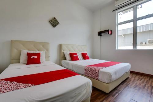 two beds with red pillows in a room at Selesa View Bukit Gambir in Bukit Gambir