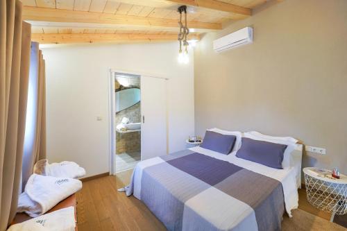 a bedroom with a large bed with blue pillows at Natura Bungalows-Villa in Limenas
