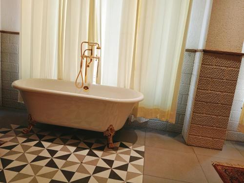 a bath tub sitting on a tiled floor in a bathroom at HOTEL CENTRA in Mohali