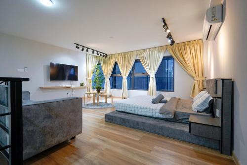 a bedroom with a large bed in a room with windows at Arte Cheras by Just Stay in Kuala Lumpur