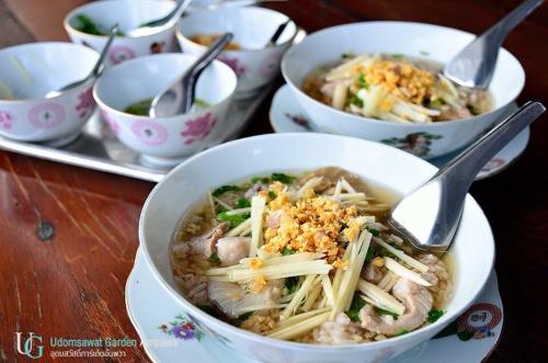 a bowl of noodles and meat with a spoon in it at บ้านสวนอุดมสวัสดิ์ อัมพวา in Amphawa