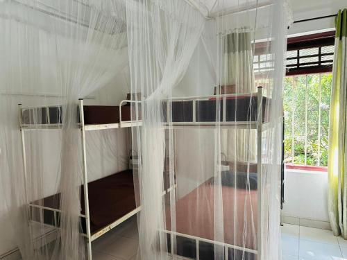 a bedroom with two bunk beds with mosquito nets at Rock View Hostel Ella in Ella