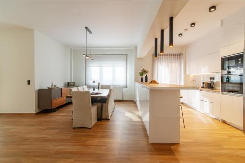 eine Küche und ein Wohnzimmer mit einem Tisch und einem Esszimmer in der Unterkunft Central Marousi 3BR Gem in Athen
