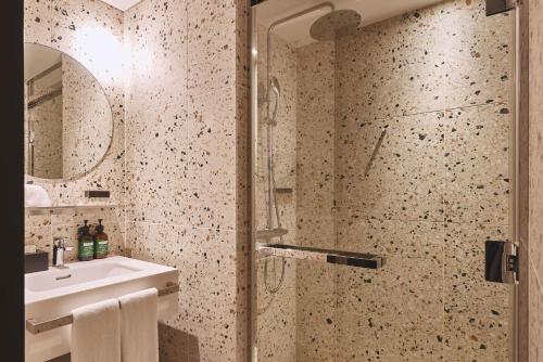 a bathroom with a shower and a sink at voco Osaka Central by IHG in Osaka