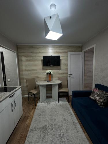 a living room with a table and a blue couch at Sport Hotel Terra in Ustʼ-Kamenogorsk