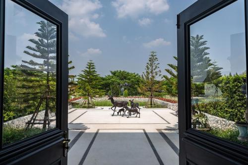 an open door with two deer statues outside at Estella Khao Yai in Khao Yai