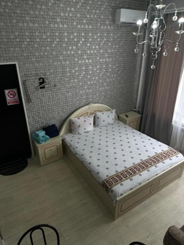 a bedroom with a bed with a chandelier at Sport Hotel Terra in Ustʼ-Kamenogorsk