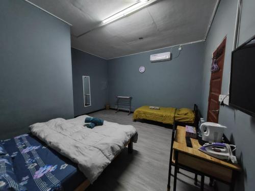 Habitación hospitalaria con 2 camas y mesa en ROO STAy TOK WAN 1, en Kampong Nail