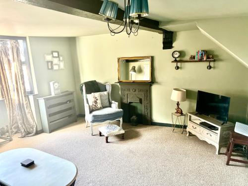 ein Wohnzimmer mit Sessel und Fernseher in der Unterkunft Little Libertys in Shrewsbury