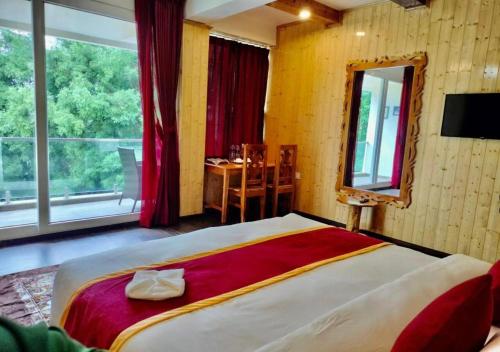 a bedroom with a large bed with a large window at Amaira Resort & Farms - Mirik, West Bengal in Mirik