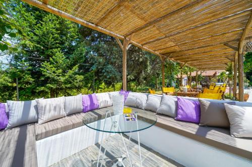 a patio with a couch and a glass table at Natura Bungalows in Limenas
