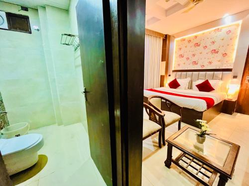 a bathroom with a bedroom with a bed and a tub at The Ramawati - A Four Star Luxury Hotel Near Ganga Ghat in Haridwār