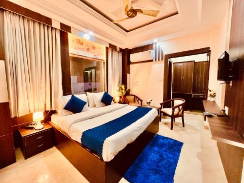 ein Schlafzimmer mit einem großen Bett und einem blauen Teppich in der Unterkunft The Ramawati - A Four Star Luxury Hotel Near Ganga Ghat in Haridwar