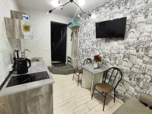 a kitchen with a tv on a brick wall at Sport Hotel Terra in Ustʼ-Kamenogorsk
