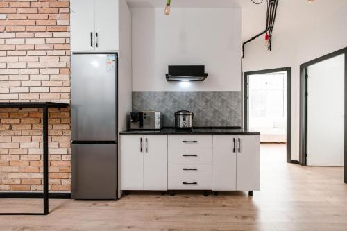 a kitchen with white cabinets and a refrigerator at 68 Hostel in Bishkek