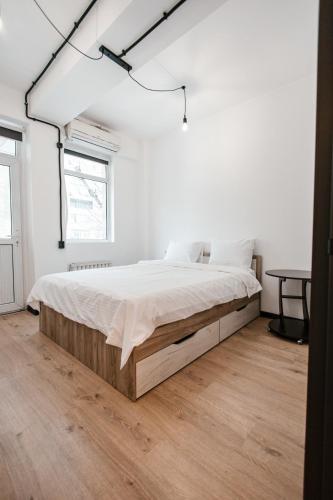 a bedroom with a large bed in a white room at 68 Hostel in Bishkek