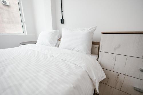 a white bed with white sheets and a window at 68 Hostel in Bishkek