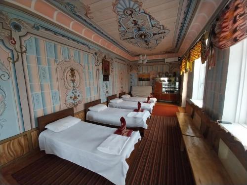 Una fila de cuatro camas en una habitación en Reyhana Unique House, en Samarkand