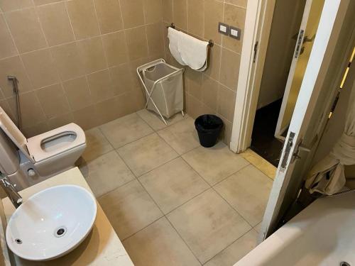 een badkamer met een toilet en een wastafel bij بالم هيلز ذا فيلج in Caïro