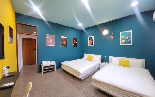 竹山鎮的住宿－布拉諾主題民宿，配有两张床铺的蓝色墙壁和灯