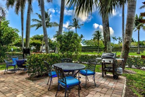 a patio with a table and chairs and a grill at Le Malo Vacation Rental in Naples