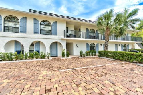 a building with a palm tree in front of it at Le Malo Vacation Rental in Naples