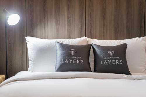 a bed with two pillows on top of it at Layers Hotel Busan Hadan in Busan