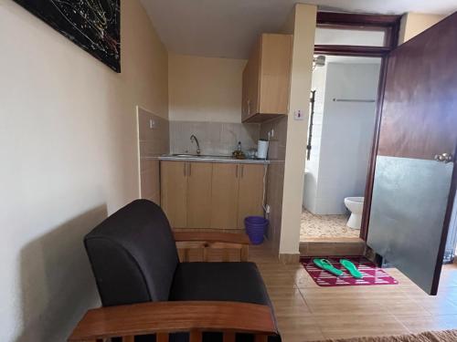a small kitchen with a chair and a sink at Citypal Apartments in Meru