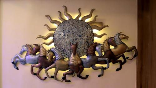 a metal wall art with horses on a wall at Hotel Executive Tower in Kolkata