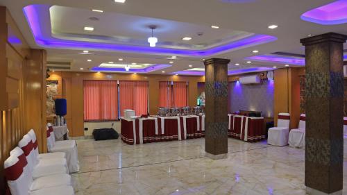 a banquet hall with tables and chairs and purple lights at Hotel Executive Tower in Kolkata